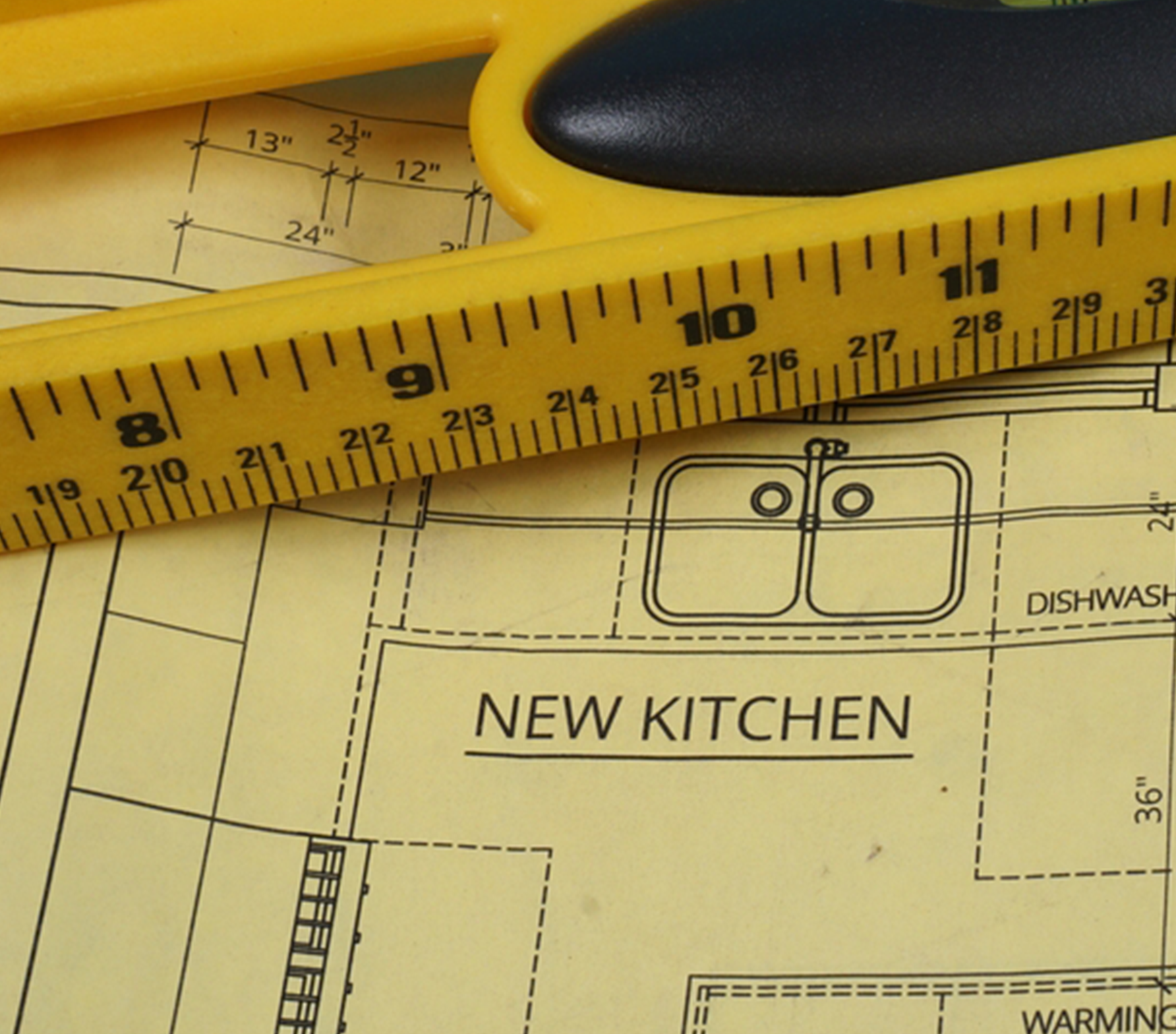 Yellow tape measure sitting on kitchen remodel plans